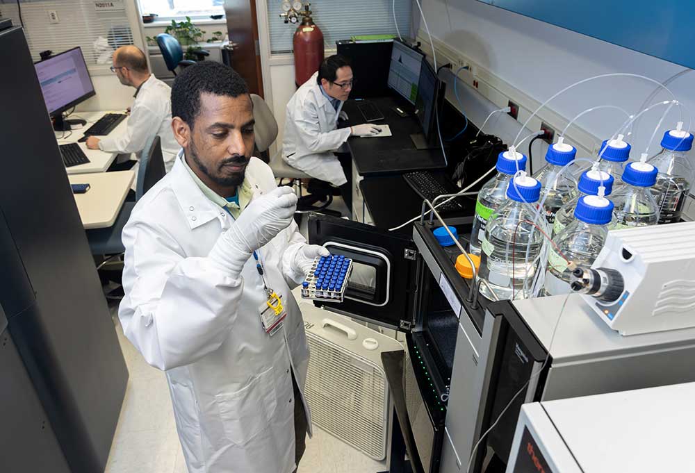 Foto de un investigador con bata blanca de laboratorio.